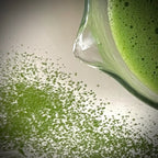 De tuit van een met matcha gevulde glazen matcha kom.