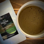 Zakje 'Premium Hojicha latte' van The Matcha Man uit Japan, een witte matcha kom gevuld met hojicha op een serveerblaadje.