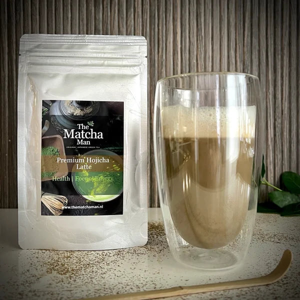 Hersluitbaar zakje 'Premium Hojicha latte' van The Matcha Man uit Japan, een dubbelwandig glas met hojicha latte en een bamboelepel.