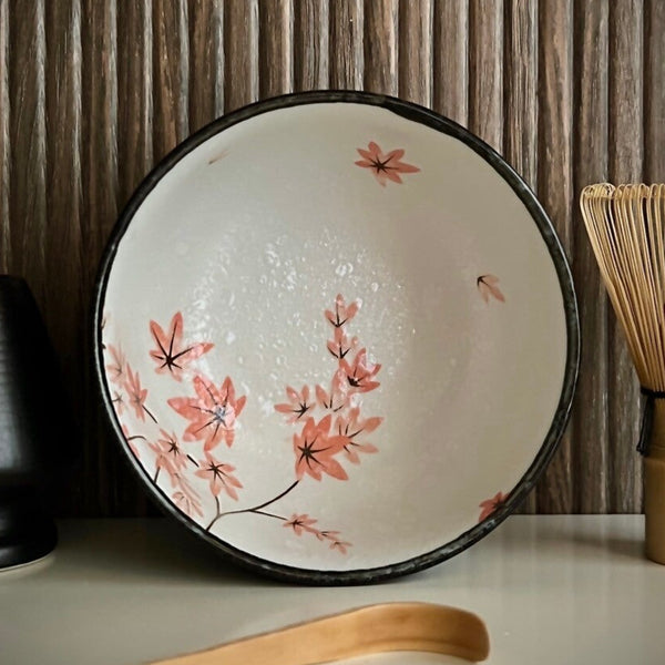 Binnenkant van een matcha kom van keramiek met oudroze bloesemtakken en antracietgrijze buitenkant.