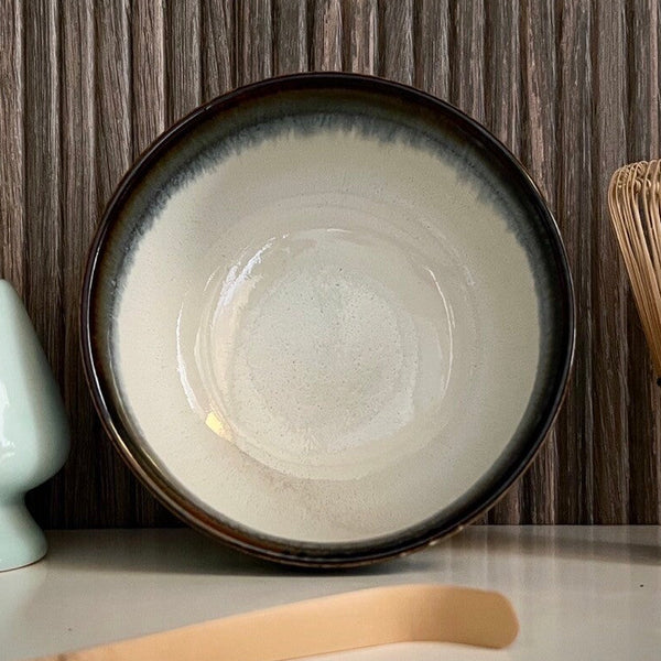 Binnenkant van een lichtblauwe matcha kom van keramiek met zwarte rand.