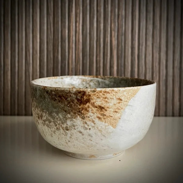 Voorkant van ecru matcha kom met diverse groen-bruine tinten.