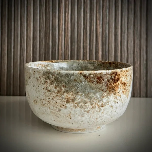 Achterkant ecru matcha kom met diverse groen-bruine tinten.