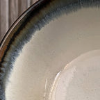 Clse up van lichtblauwe matcha kom met bruine rand.