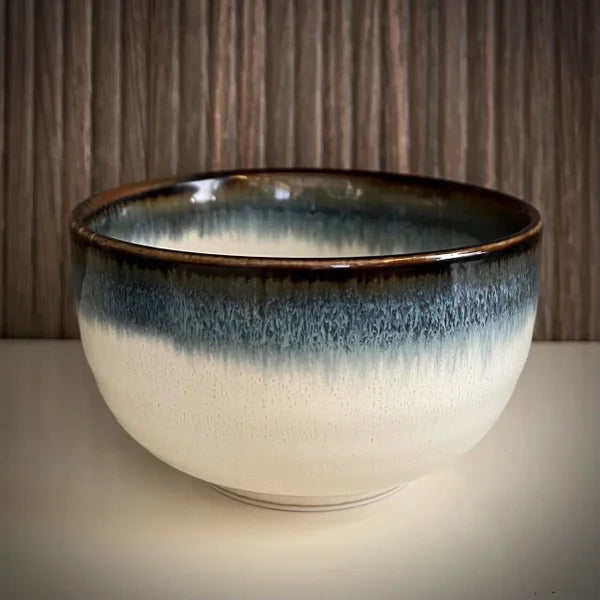 Voorkant van  lichtblauwe matcha kom met bruine rand.