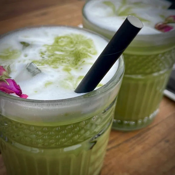 twee glazen matcha latte iced met zwart rietje
