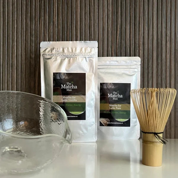 Matcha set van The Matcha Man , bestaande uit hersluitbaar zakje 'Matcha for Latte Pure' en hersluitbaar zakje 'Matcha for Latte Vanilla', een bamboe matcha klopper een glazen matcha kom met tuit.