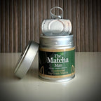 Zilverkleurig potje 'Ceremonial Top Grade Matcha' van The Matcha Man (30 gram) met opengetrokken clipdeksel en los bovendekseltje.