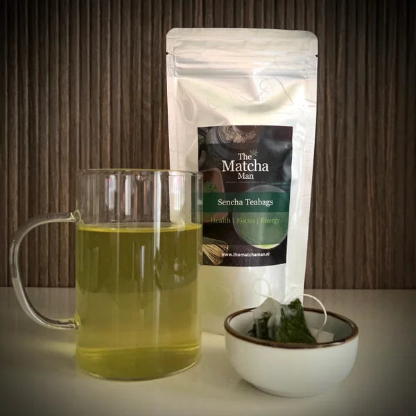 Hersluitbaar zakje 'Sencha Teabags' uit Japan van The Matcha Man, glas met sencha thee en een piramide buideltje in een bakje.