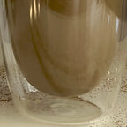 Close up van een dubbelwandig theeglas gevuld met hojicha.