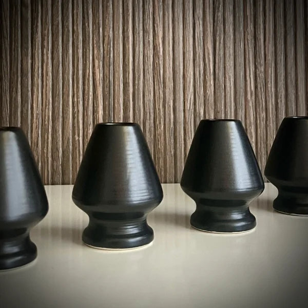 Vier matzwarte whiskhouders op een rij.