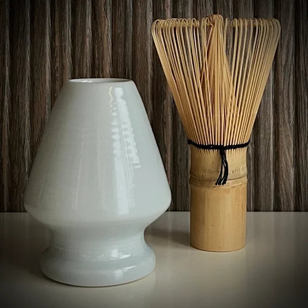 Bamboe matcha klopper  naast lichtblauwe whiskhouder.