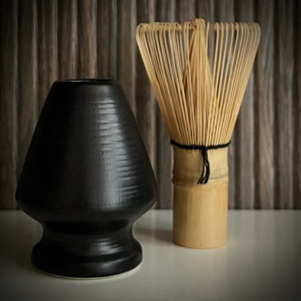 Bamboe matcha klopper naast een matzwarte whiskhouder.