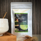 Hersluitbaar zakje 'Ceremonial High Grade Matcha' van The Matcha Man (25 gram)  met bamboe matcha klopper en matcha kom op serveerblaadje.