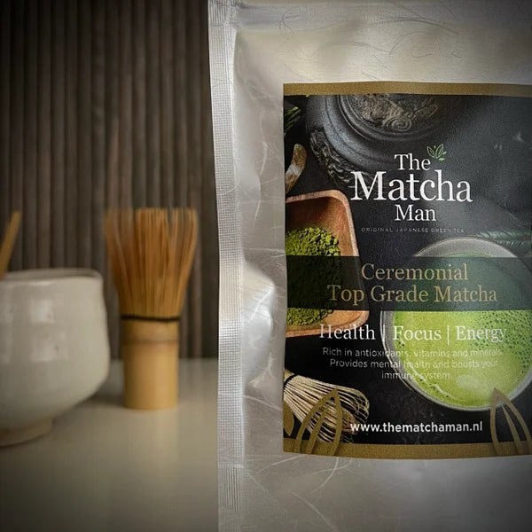 Hersluitbaar zakje 'Ceremonial Top Grade Matcha' van The Matcha Man (25 gram)   met matcha kom en bamboe matcha klopper op achtergrond.